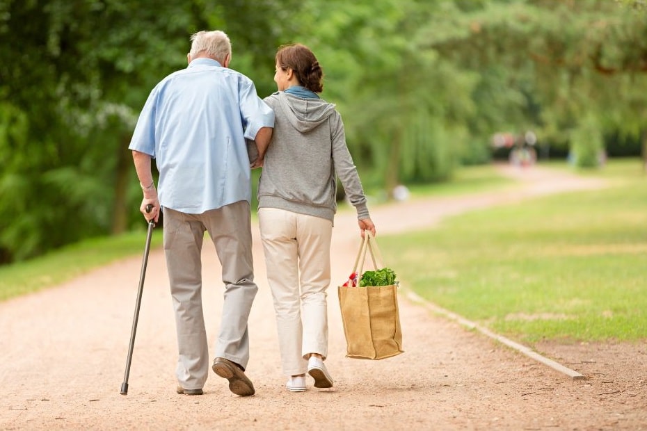 femme et homme âgé marchant dans un parc